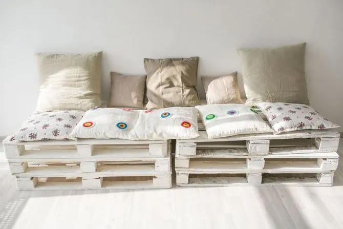 Скамейка из поддонов, декорированная красивыми льняными подушками
